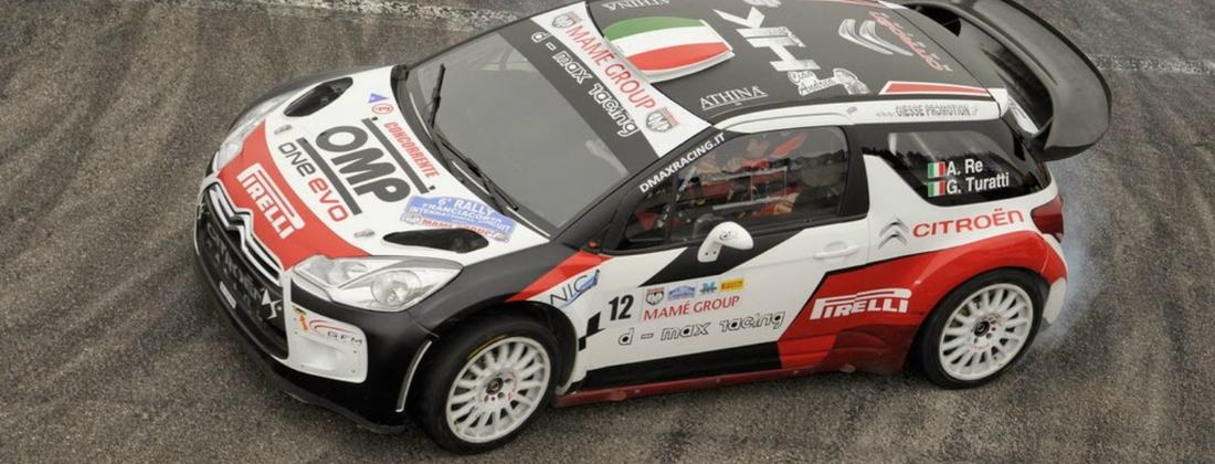 Citroën DS3 WRC da rally con livrea bianca, rossa e nera in curva su asfalto