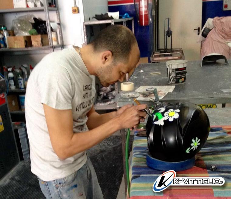 In officina, margherite dipinte all'aerografo su un casco jet nero