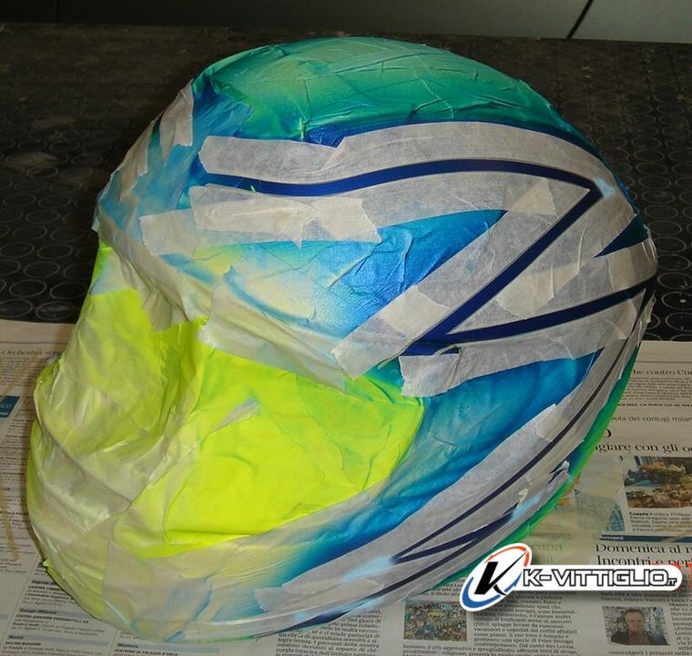 Casco coperto di nastro di mascheratura, con le prime sfumature gialle e azzurre all'aerografo
